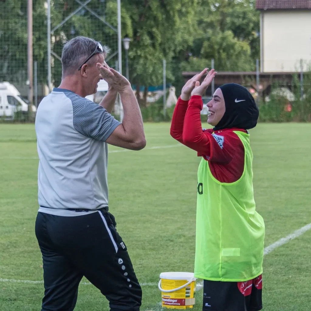 Trainer der FC Perg Ladies Hans Joachim Riegler schlägt mit der Kapitänin ein